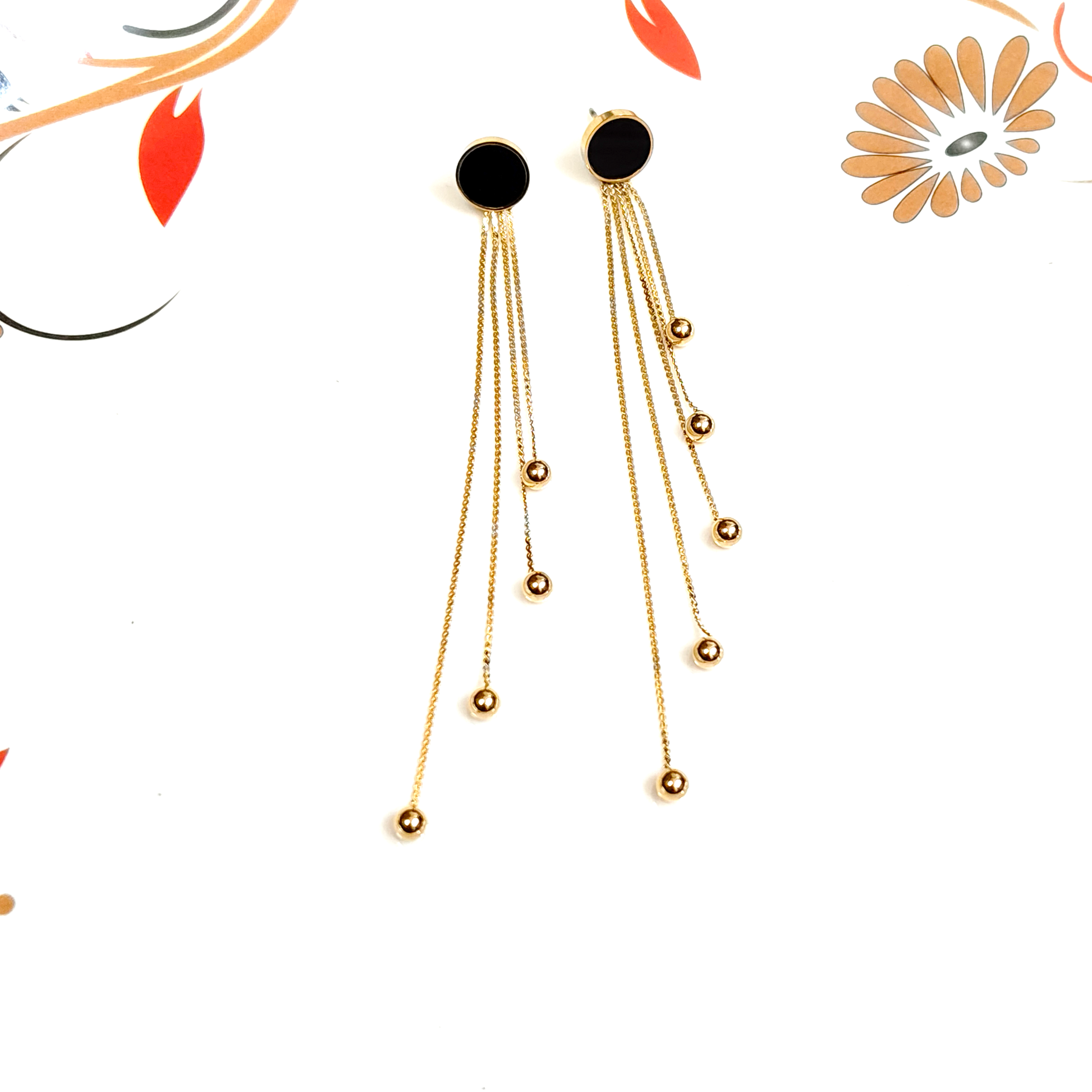 Gold earrings with black stones on a white background