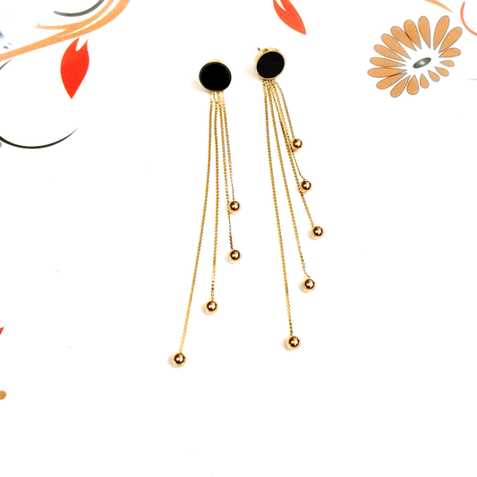 Gold earrings with black stones on a white background